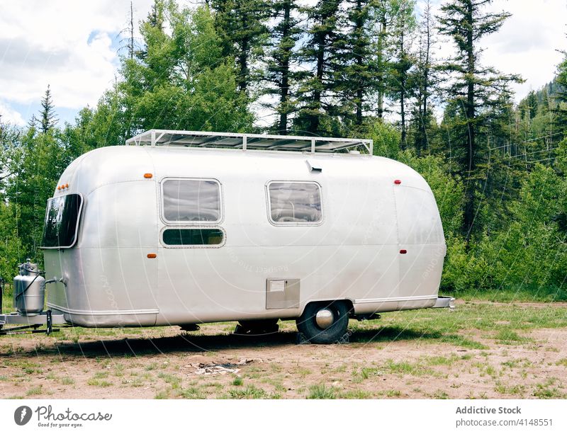 Metal camper in highland area travel trailer mountain landscape amazing vehicle caravan range forest usa united states america explore wanderlust journey green