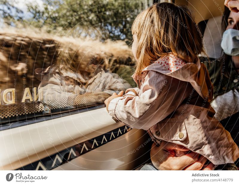 Mother and daughter in train travel window mother child together coronavirus mask protect passenger seat little girl journey epidemic medical calm kid transport