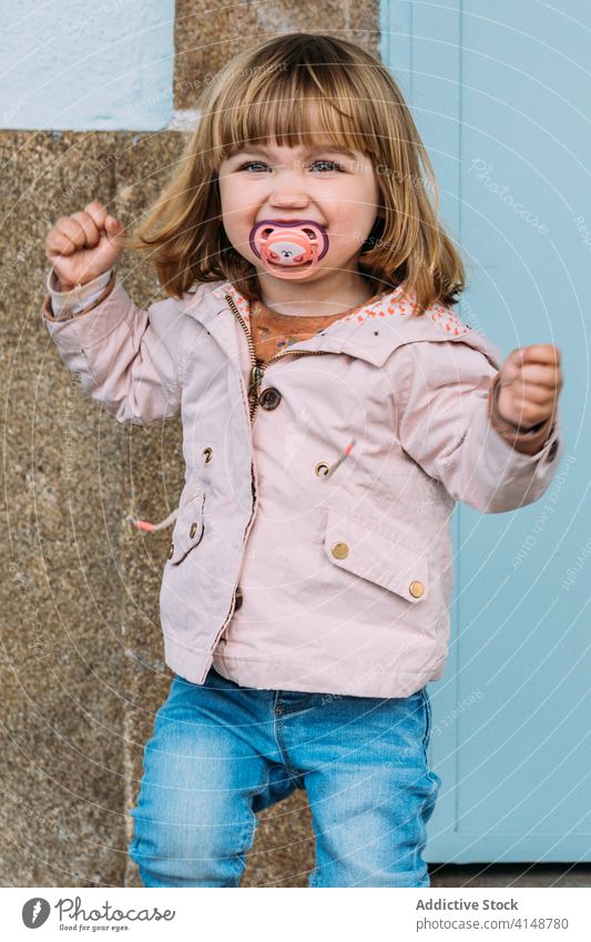 Cheerful child at railway platform railroad wait cheerful little curious girl public positive kid adorable transport happy station city urban joy charming