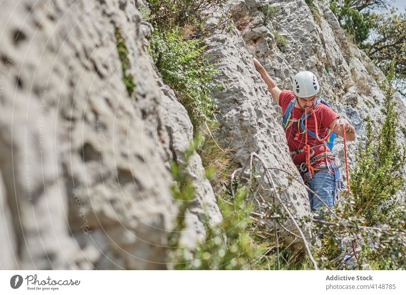 Male alpinist on rope on rock climb mountaineer man extreme risk safety alpinism male adventure equipment steep summer vacation nature challenge explore journey