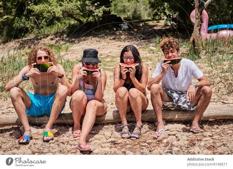 Group of people eating watermelon friend together enjoy summer holiday sweet delicious forest tree log company group relax season chill friendship happy tasty