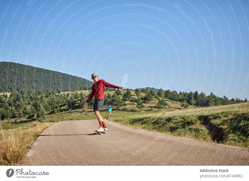 Young man riding skateboard in park ride hipster road summer trendy fancy skater male style hobby modern active activity handsome motion freedom enjoy guy focus