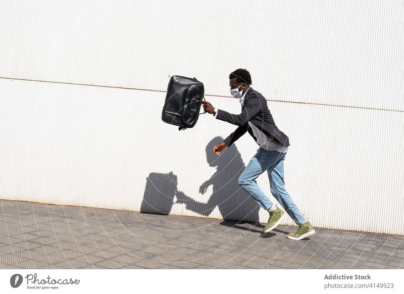 Businessman with suitcase running on street businessman hurry rush urban fast mask modern concept young african american black ethnic briefcase success goal