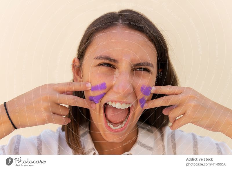 Aggressive woman painting face in city girl power concept war feminism strong demonstrate scream female gesture confident cry strength pose posture effort