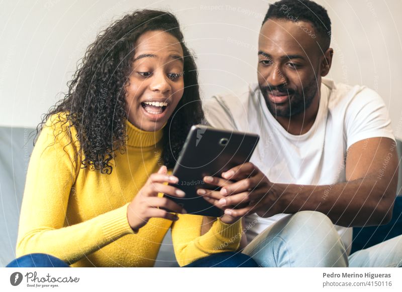 afro american couple watching tablet at home man woman internet black people happy technology smiling young online movie lifestyle african american female adult