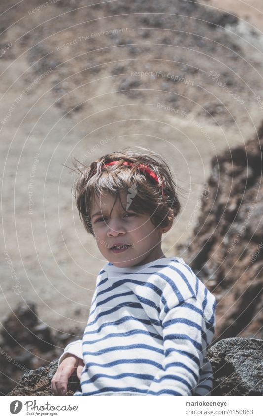 Portrait of a little Caucasian girl with short hair with a volcanic background tranquility pensive one person thoughtful haircut vertical relaxation standing