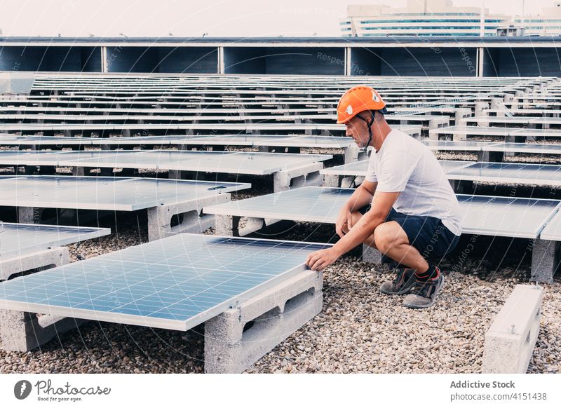 Busy workman near solar batteries panel battery install sustainable industrial alternative power male engineer development energy resource area plant helmet