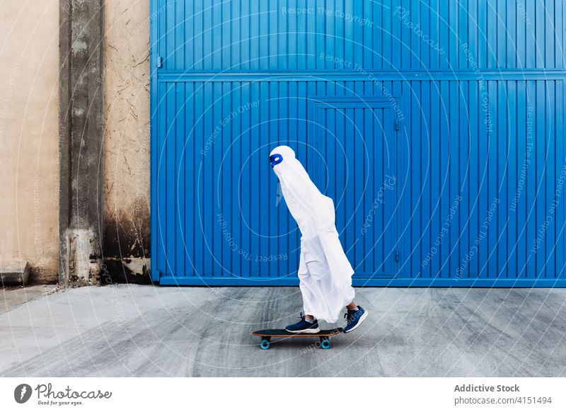 Kid in ghost costume on street halloween child holiday kid skateboard skater creepy event autumn scary entertain spooky celebrate season fall fantasy tradition