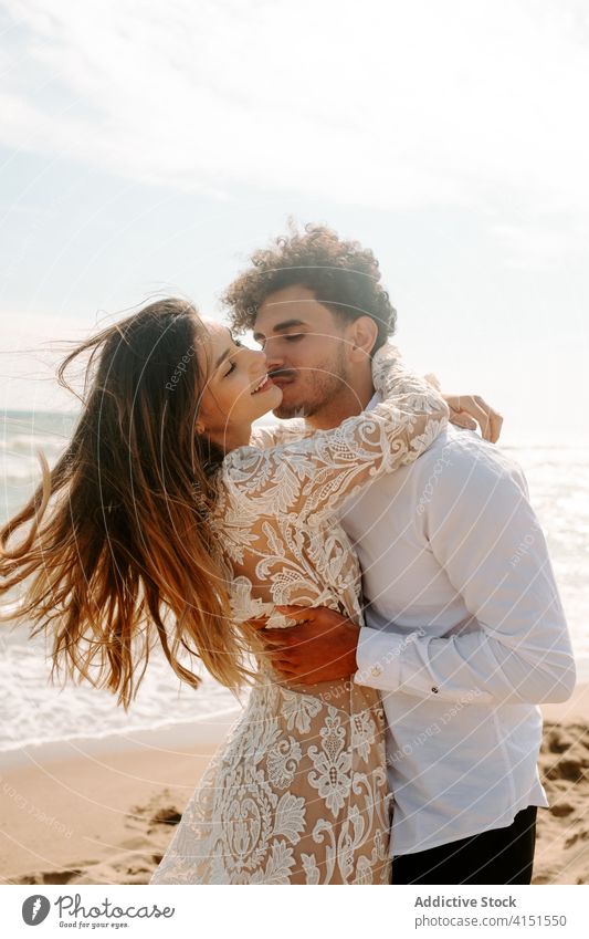 Happy newlywed couple standing against waving sea beach romantic happy cheerful together embrace relationship love nature sand gentle seaside harmony amorous