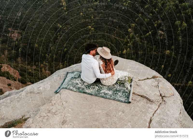 Romantic couple kissing on top of mountain romantic newlywed love young rock cliff nature together relationship wedding bride groom spain morro de labella