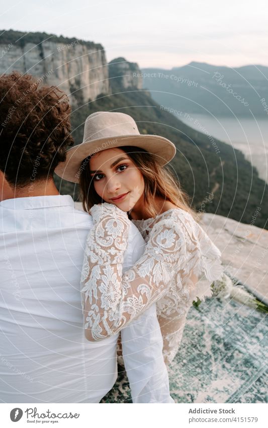 Tender newlywed couple embracing each other in mountains romantic woman love young rock kiss happy nature together relationship wedding boho bride groom spain