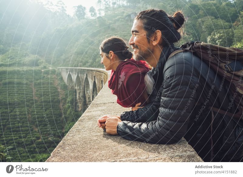 Ethnic travelers standing on old bridge in jungle nature forest hiker couple friend activity tourism ethnic happy laugh cheerful sri lanka nine arch bridge