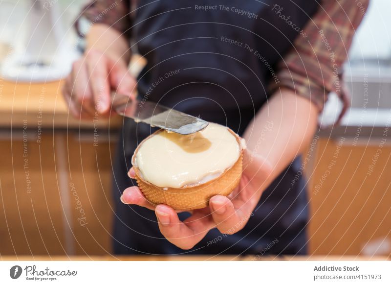 Anonymous baker preparing delicious tarts at home cream pastry prepare kitchen table cook fill shortcrust small business curd utensil spatula professional ready