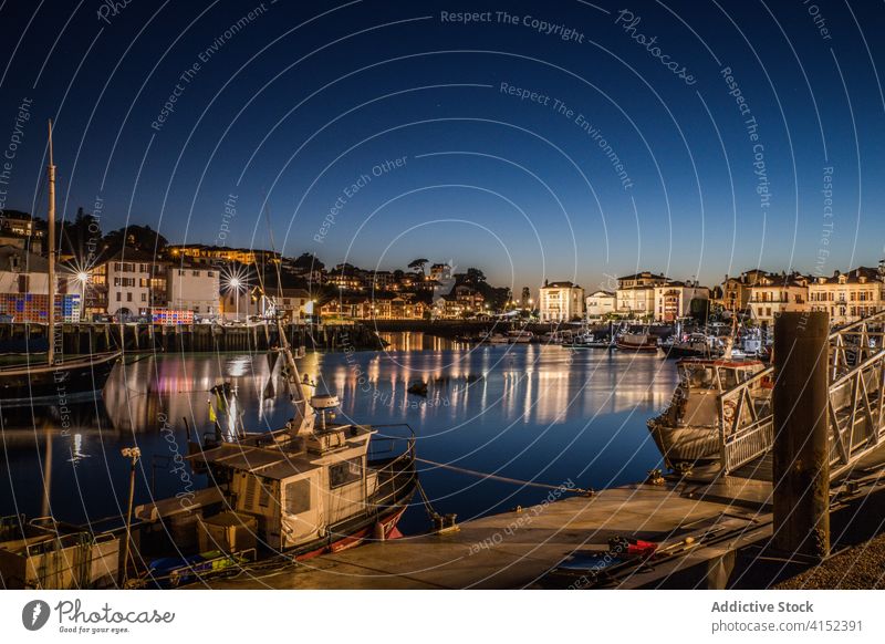 Coastal town with port and boats at night city harbor urban illuminate building coast cityscape picturesque water reflection travel tourism architecture