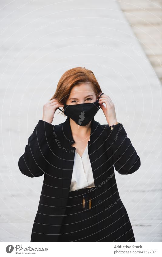 Confident woman in suit in city businesswoman elegant entrepreneur determine reliable confident mask coronavirus female protect building professional serious