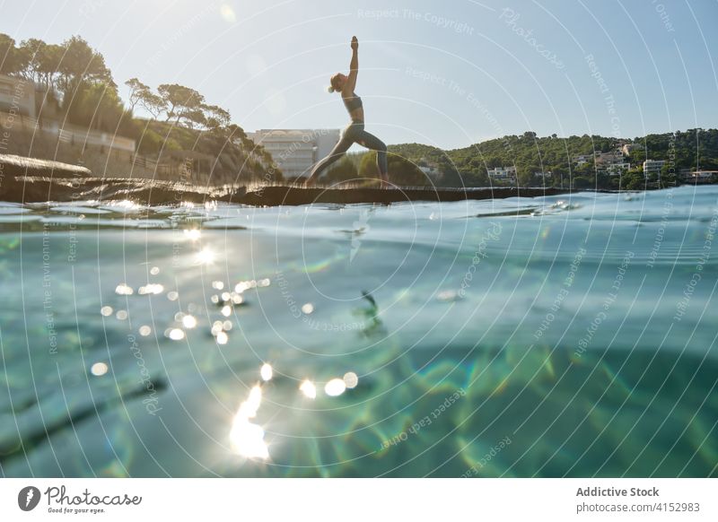 Woman doing yoga near sea woman practice asana pose mountain pose urdhva hastasana stand seashore harmony wellness lifestyle female nature vitality stretch