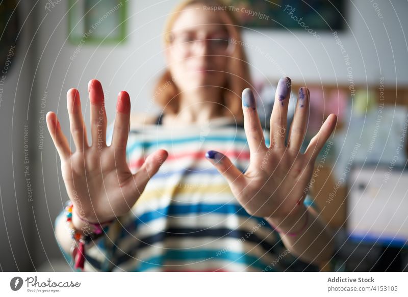 Craftswoman with painted hands in studio finger artist painter colorful watercolor pigment workshop female creative inspiration professional modern young hobby