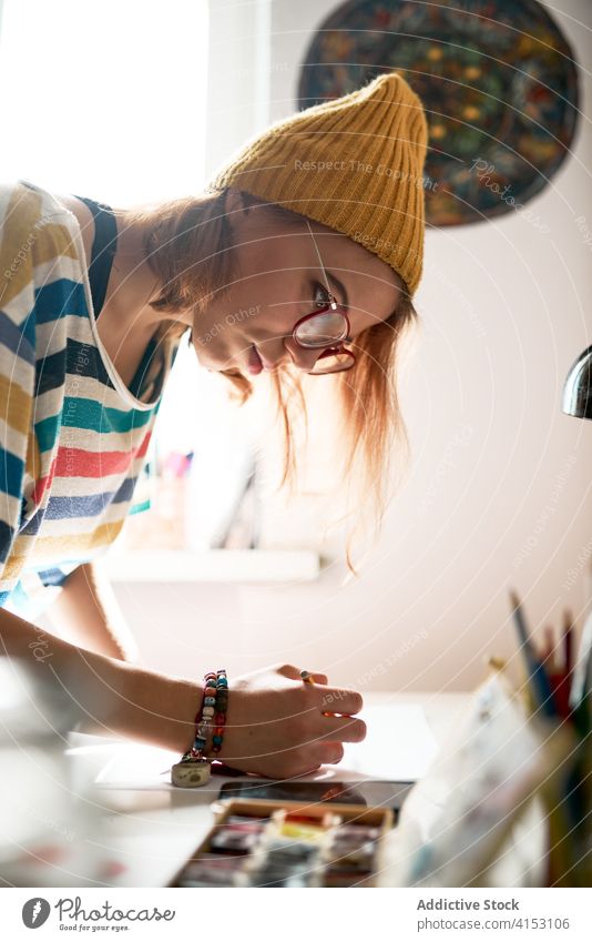 Cheerful woman painting in workshop artist watercolor create craftswoman cheerful skill painter artwork female hobby inspiration trendy studio paper creative