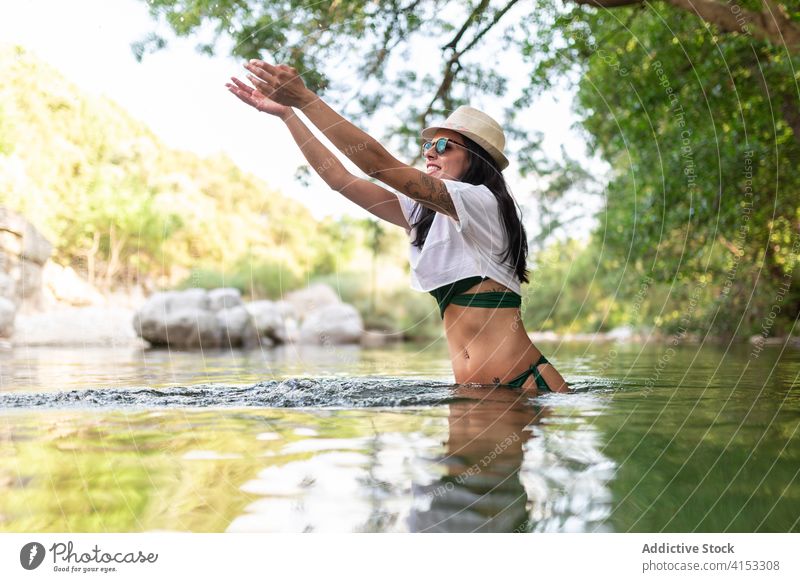 Calm woman in lake in summer forest travel enjoy vacation water pond relax female traveler carefree trip calm tourism holiday tranquil nature idyllic green