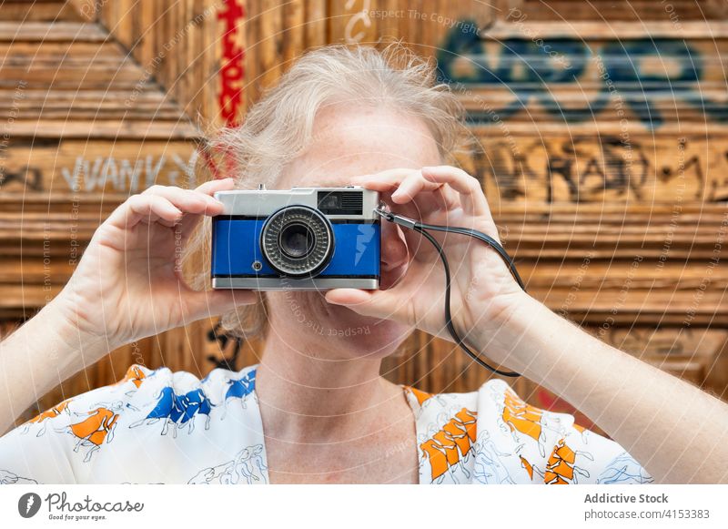 Mature woman taking photo on camera vintage photo camera take photo travel street traveler content mature memory female moment photography trip device city