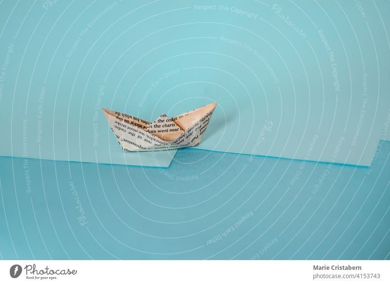 Conceptual photo of a paper boat made from old newspaper, showing concept of economy and finance sparse copy space day indoors no people creative idea transport