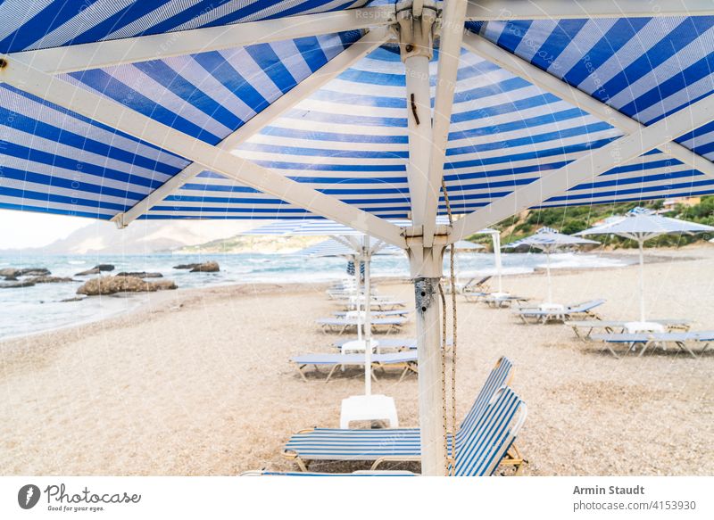 deckchairs and parasols at an empty beach background bay blue cloudscape coast coastline holiday journey landscape leisure mountain nature nobody ocean outdoor