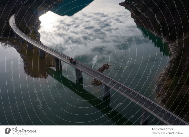 Truck on suspension bridge over river truck drive road calm landscape autumn reflection germany austria transport water peaceful tranquil scenic freedom