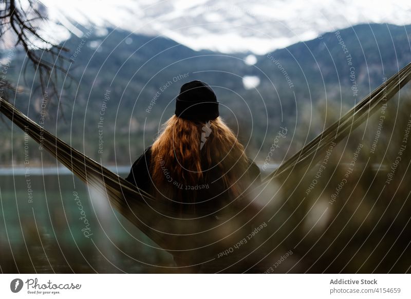 Woman relaxing in hammock near lake woman mountain admire scenery pond highland autumn female germany austria majestic nature traveler serene tourism peaceful