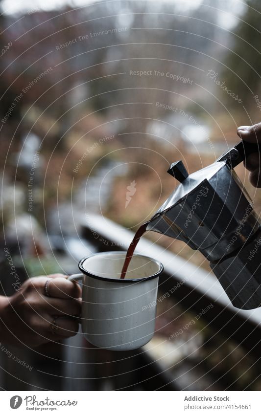 Traveler pouring hot coffee into mug in autumn nature travel enamel hot drink break rest together countryside beverage cup relax trip journey warm season