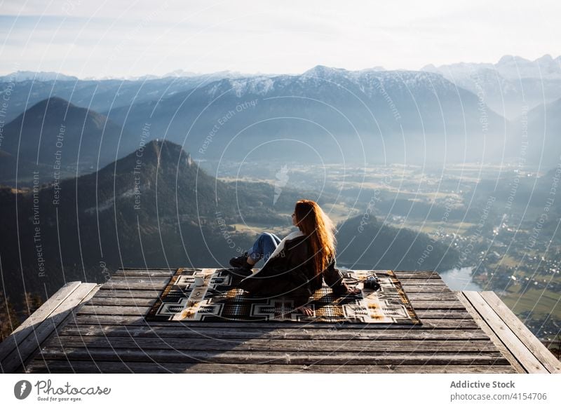 Traveling woman on wooden terrace in highlands viewpoint mountain morning traveler sitting fog sunbeam tranquil enjoy germany austria tourist scenery amazing