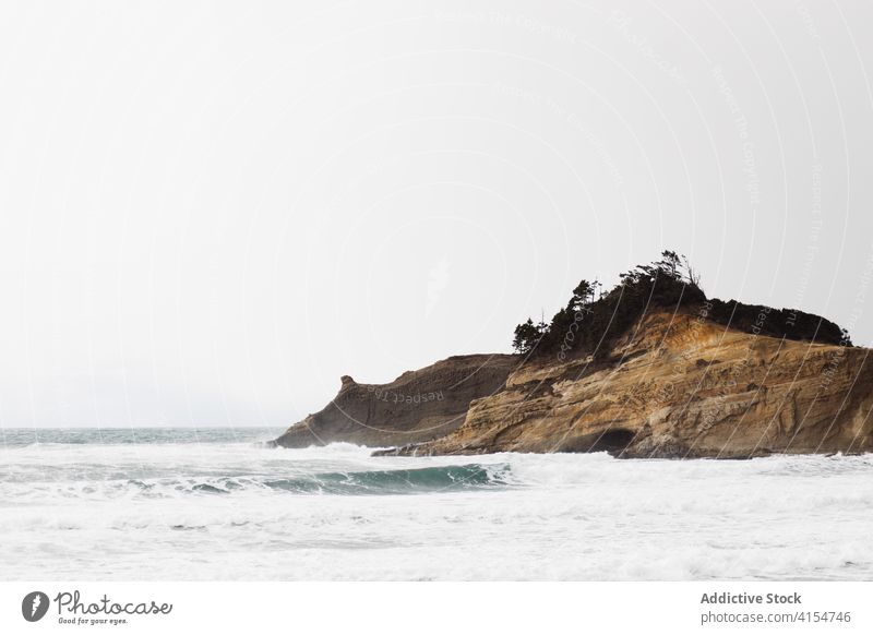 Scenery of hill near sea on cloudy day foam beach gloomy seascape scenery gray sky usa america united states landscape nature water idyllic coast freedom serene