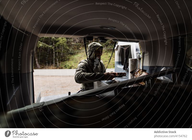 Man cooking lunch in traveling van wanderlust man adventure autumn vehicle car male usa america united states prepare weekend serious explorer season holiday