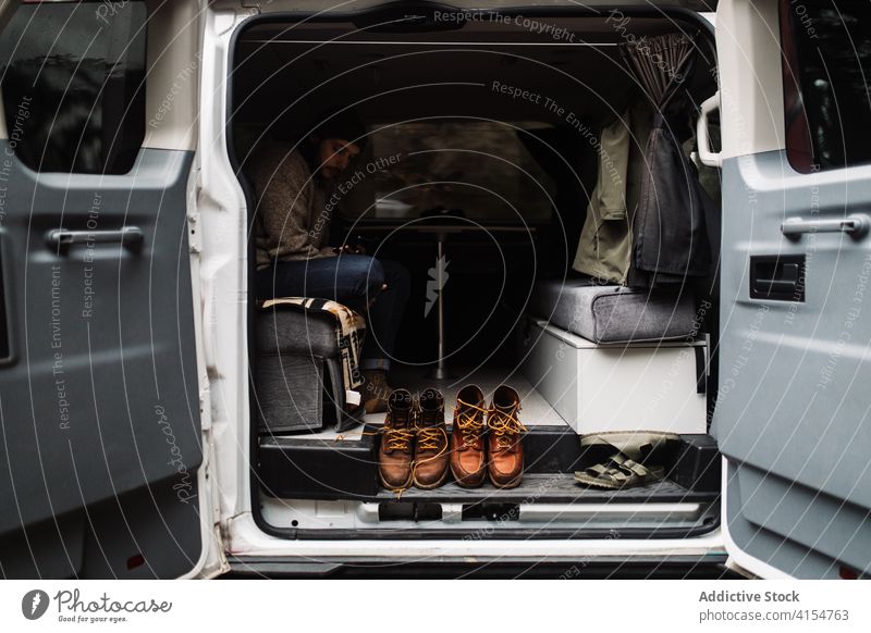 Man relaxing in van during journey in autumn travel man transport trip parked traveler male usa america united states cloudy vehicle vacation freedom weekend