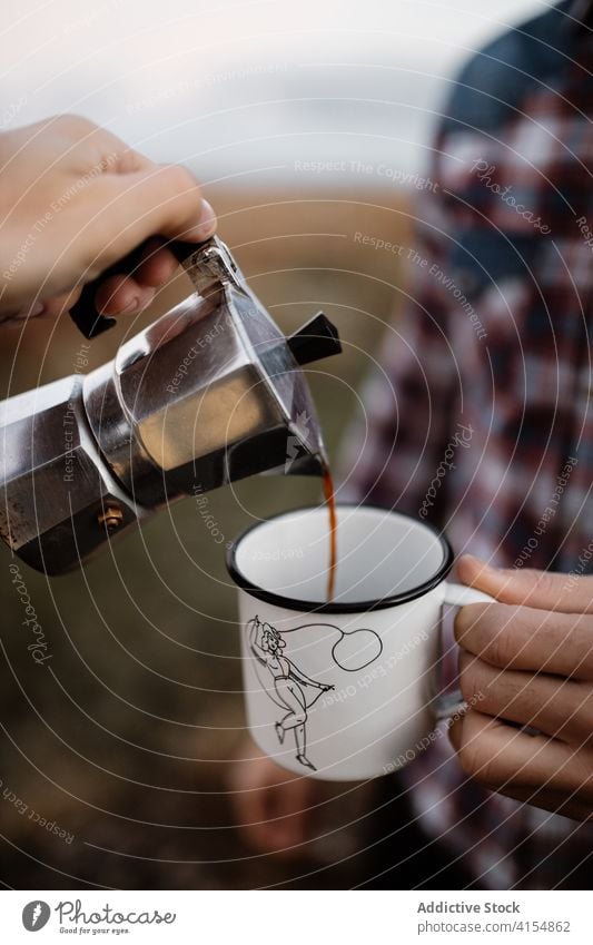 Crop travelers pouring coffee in metal cup tourist together hot drink adventure geyser coffeemaker scottish highlands scotland uk united kingdom mug vacation