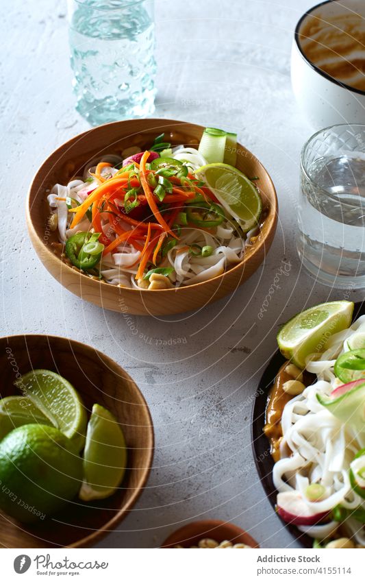 Vegan rice noodles salad food vegan top view cucumber vegetable lime peanut sauce asian cookery chinese fresh dinner green healthy bowl eating chopstick