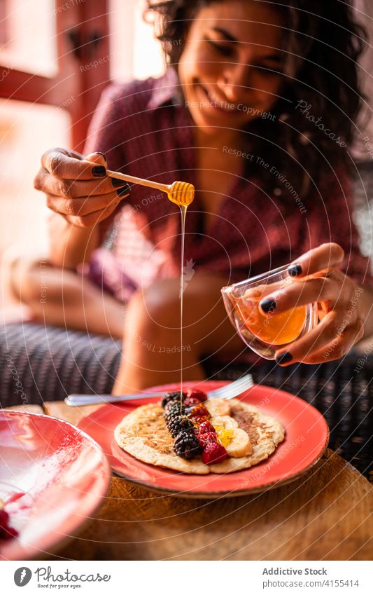 Woman eating healthy pancakes for breakfast plate smile sweet fresh tasty gastronomy fruit delicious raspberry honey organic food latin enjoy blueberry