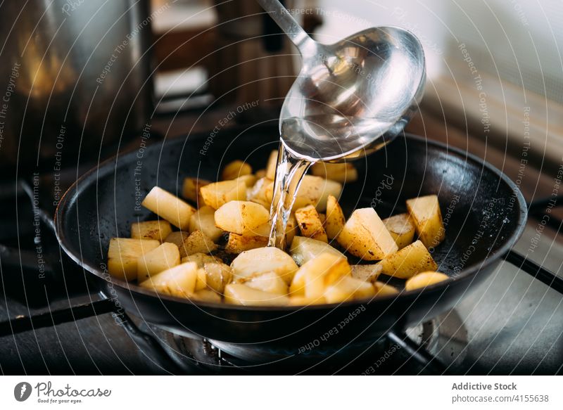 Woman cooking a vegetable soup with pumpkin, potato and onion fry pan prepare spoon water ingredient pour stir food recipe kitchen spatula mix cuisine culinary