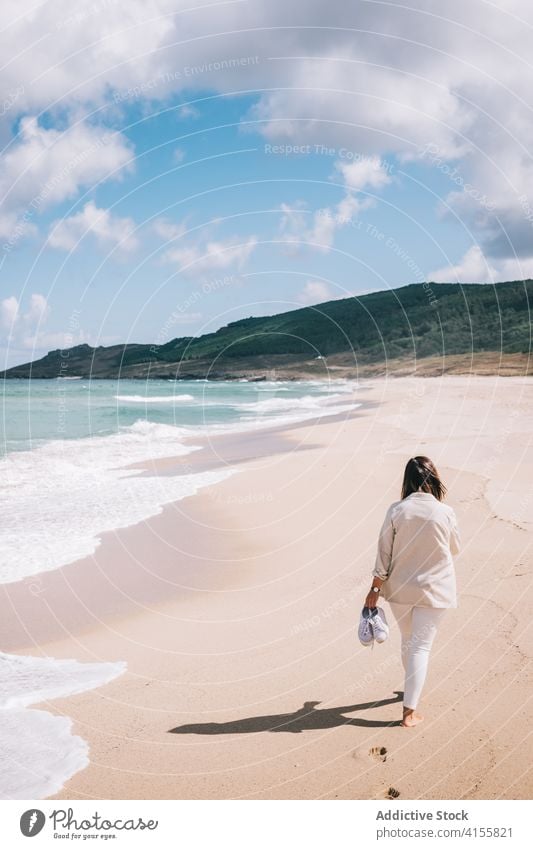 Woman walking admiring waving sea on beach woman wave sand fresh stormy alone seaside shore female travel tourism spain barefoot enjoy relax recreation breeze