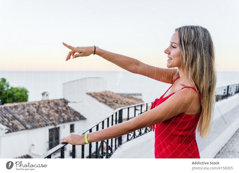 Content woman on balcony in old city tourist terrace cityscape admire observe summer enjoy smile female railing amazing lean rest vacation sunset tourism stand