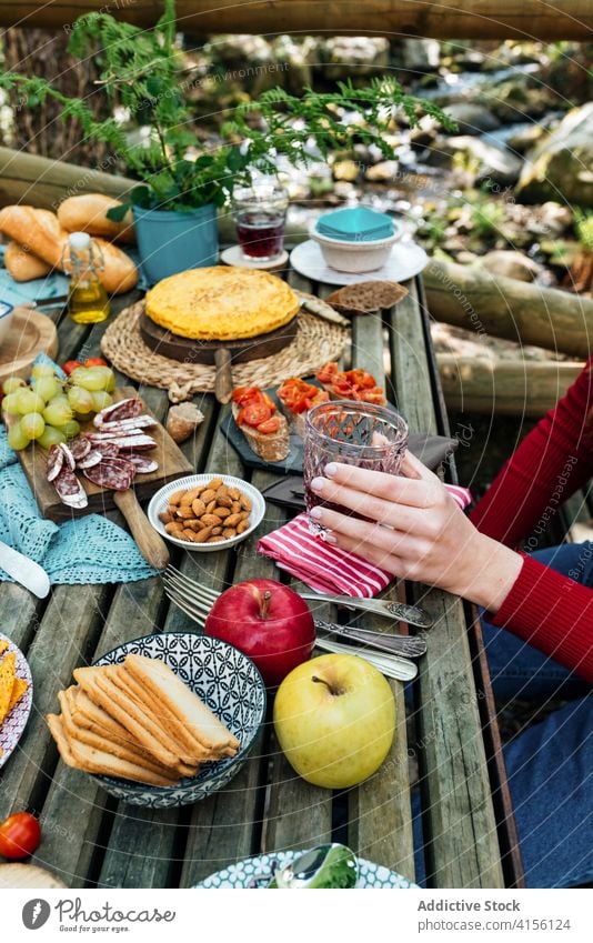 Crop women at table with food in forest picnic together eat various woods delicious valle del jerte caceres spain tasty wooden meal friend lunch vacation snack