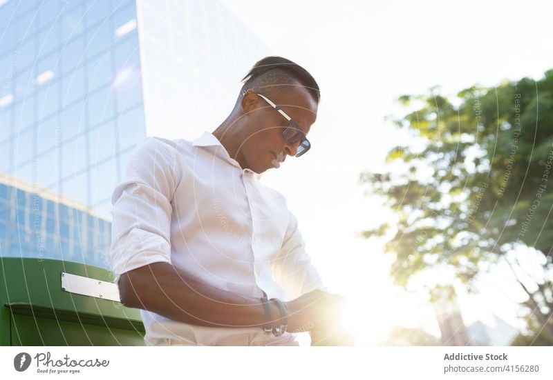 Determined ethnic male entrepreneur walking on street businessman city style trendy determine gentleman jacket black african american urban executive serious