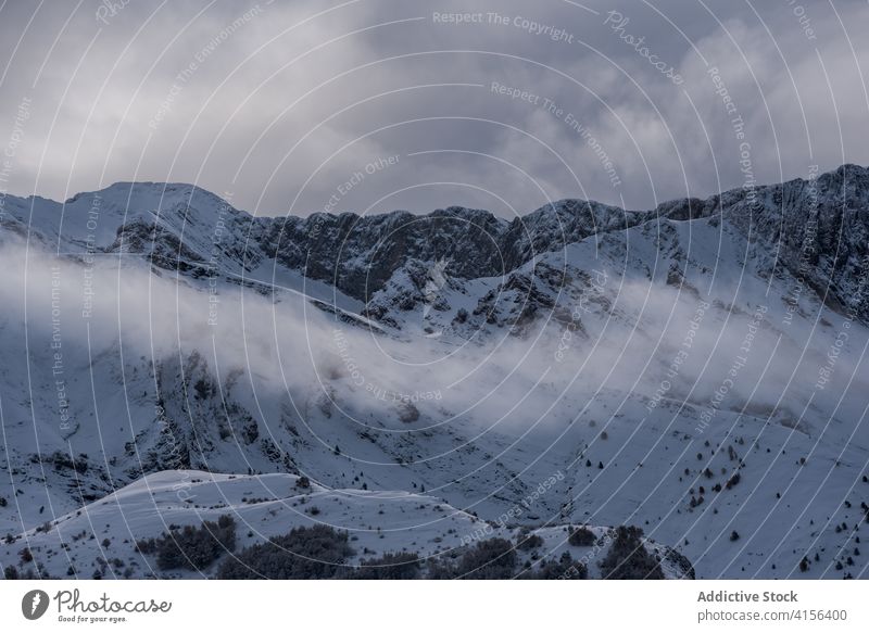 Snowy mountain ridge in winter range snow cloudy sky fog dramatic highland landscape amazing pyrenees huesca spain scenery spectacular cold nature environment