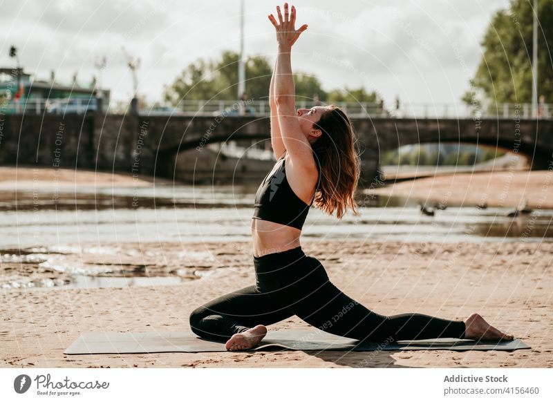 Woman in Half Pigeon pose practicing yoga on beach half pigeon pose woman flexible asana ardha kapotasana practice mindfulness stress relief summer female mat