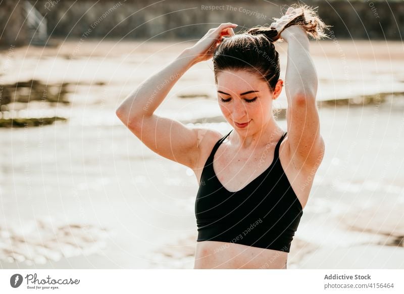 Woman in sportswear preparing for yoga exercises ponytail woman yogi prepare slim slender peaceful harmony beach female summer river river bank riverside bra