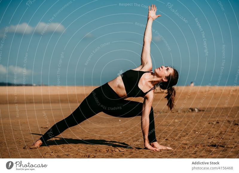 Flexible woman doing yoga in Extended Side Angle Pose beach pose practice flexible summer asana female slim sportswear fit relax Utthita Parsvakonasana vitality