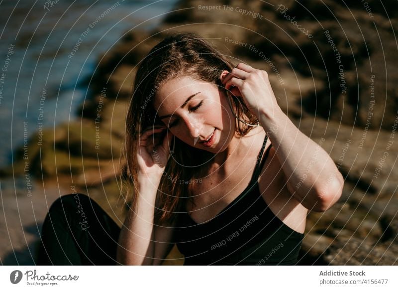 Woman listening to music in earphones enjoy tranquil woman calm river shore carefree female sunny harmony eyes closed relax sit modern sound idyllic lady