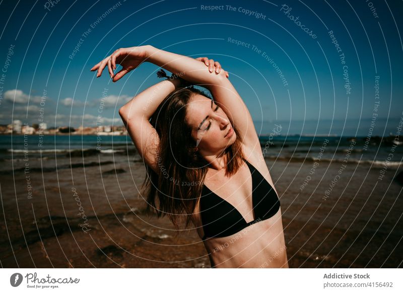 Slender woman doing yoga on the beach asana practice slim tranquil seashore bikini female amazing seascape stretch wellness peaceful zen posture nature