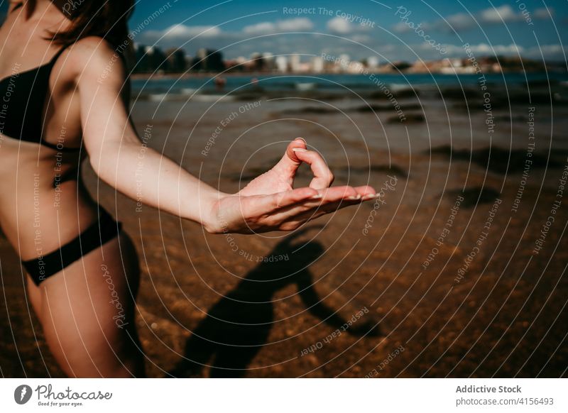 Crop woman practicing yoga in Mountain pose on beach mountain pose mudra gesture practice urdhva hastasana slim seashore female summer wellness seaside nature