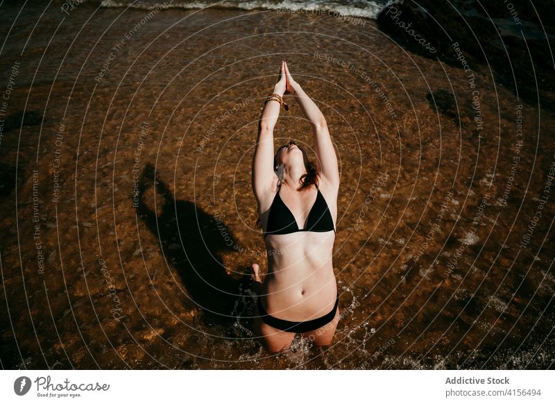 Woman doing yoga in Camel pose near sea camel pose namaste gesture woman practice ustrasana flexible yogi female healthy balance calm position serene peaceful