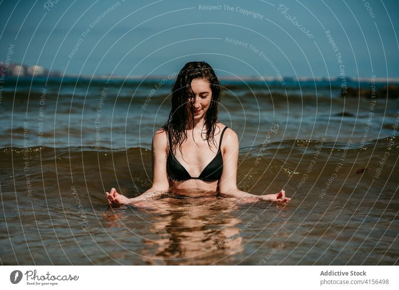 Woman practicing yoga with mudra hands gesture woman practice sit zen stress relief sea wave harmony female balance healthy tranquil asana calm idyllic fit